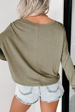 Woman in olive green V-neck dropped shoulder long-sleeve T-shirt and denim shorts