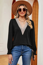 Women’s black V-neck long sleeve T-shirt with white lace trim and blue jeans