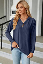 Woman in long sleeve navy blue V-neck T-shirt with buttons and jeans