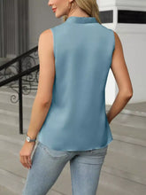 A light blue v-neck satin tank with a sleeveless design and soft flowing satin fabric with subtle sheen