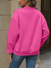 A vibrant pink oversized crewneck casual sweatshirt with ribbed cuffs made of slightly stretchy material