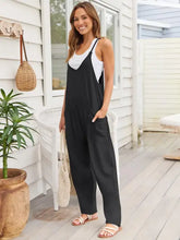 Schwarzer Jumpsuit mit Spaghettiträgern, weißem Tanktop und Seitentaschen