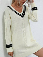 Cream-colored V-neck cable knit sweater dress with black trim