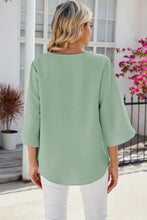 Woman in light green V-neck tunic with three-quarter sleeve length
