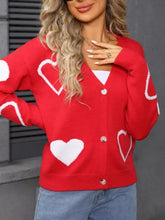 Red knit cardigan with white heart pattern, silver buttons, shoulder seam