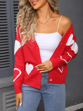 Red knit cardigan with white heart pattern at shoulder seam