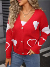 Red heart pattern knit cardigan with silver buttons at shoulder seam
