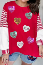 Red long-sleeved Valentines Day sweatshirt with heart-shaped sequin patches and striped color block sleeves