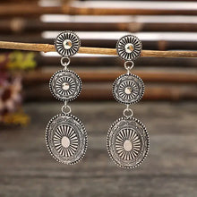 Vintage alloy dangle earrings with silver-toned intricate medallion designs