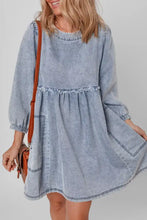 A light blue vintage wash denim dress with long sleeves flared skirt and pockets in soft denim fabric