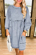 Light blue vintage wash denim dress with puffed sleeves, tiered frayed hem, and pockets in soft denim fabric