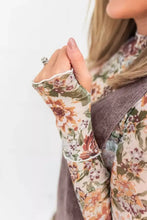 Floral-patterned long-sleeve top with sheer fabric and ruffled cuffs paired with vintage wash denim overall dress