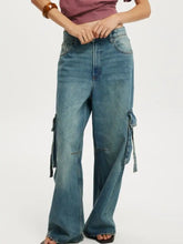 Vintage wash wide leg cargo jeans in medium-wash blue denim with side pockets and drawstrings for a relaxed fit