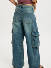 Medium-wash blue vintage wash wide leg cargo jeans featuring large flap pockets on sides and back view visible