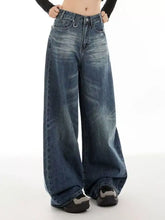 Vintage wash wide leg high-waisted denim jeans in medium blue with subtle fading and distressed details
