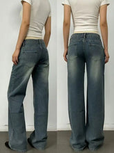 Vintage wash wide leg jeans in faded blue denim with subtle distressing and classic back pockets shown from the back side