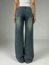 Vintage wash wide leg denim jeans in faded medium blue with subtle distressing and classic back pockets visible from the back side