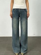 Vintage wash wide leg denim jeans in faded medium blue with subtle whiskering and distressing details
