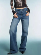 High-waisted blue denim vintage wash wide leg jeans with flared cut and classic stitching details