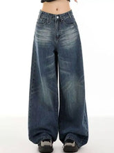 Vintage wash wide leg high-waisted denim jeans in faded dark blue with subtle distressing and classic stitching