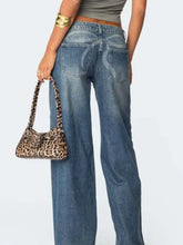 Leopard print shoulder bag with curved structured design and matching handles paired with vintage wash wide leg jeans