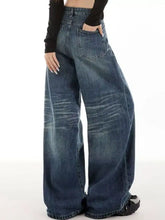 Vintage wash wide leg jeans in medium-wash blue denim with subtle fading and distressing details