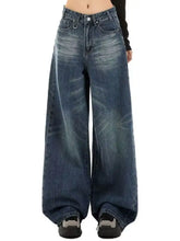Vintage wash wide leg denim jeans in medium-wash blue with faded distressing and classic stitching