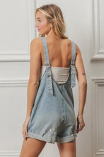 Vintage washed denim short overalls with folded hem, adjustable straps and button closure