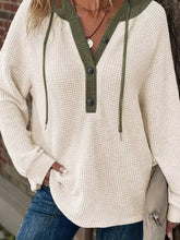 Cream-colored waffle knit button detail drawstring hoodie with olive green trim made of slightly stretchy material