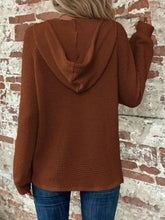 Rust-colored waffle knit button detail hoodie with long sleeves and relaxed fit featuring wool knit material and care instructions