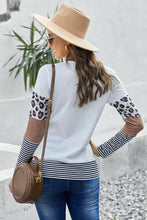 Woman in leopard round neck long sleeve t-shirt, jeans, hat, bag