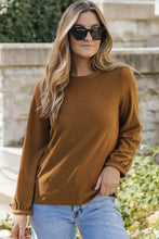 Woman in waffle-knit round neck long sleeve top and blue jeans