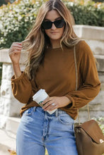 Brown ribbed waffle knit round neck long sleeve top with bell sleeves and gold chain bag