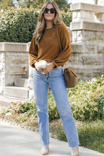 Brown waffle knit round neck long sleeve top with jeans and boots