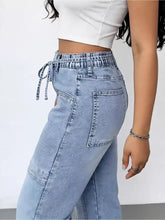 Light-wash denim wash wide leg cargo jeans with high-rise fit drawstring waistband and cargo-style pockets