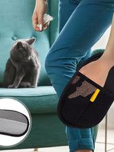 Black mesh pet hair remover slipper with sweeping motion, yellow accent