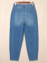 Light-wash blue denim washed cuffed barrel jeans with a high-rise waist and subtle distressing at the knees