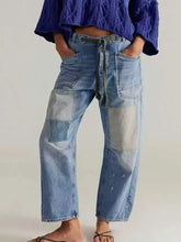 Light-wash denim washed relaxed fit jeans with patchwork design drawstring waistband and multiple pockets