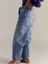 Light-wash denim wide-leg relaxed fit jeans with visible stitching details for casual wear