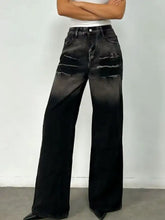 Black washed wide leg jeans made of denim with distressed faded patches on the thighs