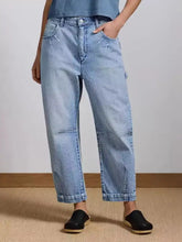 Light-wash denim wide leg jeans with relaxed fit and subtle distressing details for casual wear