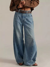 Light-wash denim washed wide leg jeans with relaxed oversized fit and visible stitching details in product descriptions