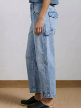 Light-wash denim wide leg jeans with a relaxed fit and visible stitching details ideal for casual wear