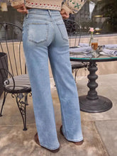 Light-wash denim wide leg jeans with a straight-leg cut and classic back pockets shown from the back side