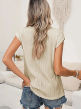 Beige wavy textured button v neck blouse with pleated short sleeves and a relaxed fit featuring subtle vertical ridges