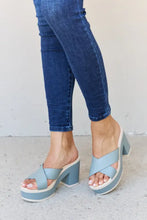Person in Weeboo misty blue contrast platform sandals with criss-cross straps and dark blue skinny jeans