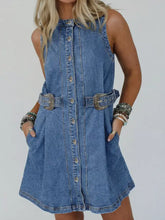 Blue denim sleeveless dress with button front and decorative western belt buckles in a short denim dress style