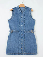 A blue sleeveless denim dress with silver buttons and decorative belt buckles in a western style design