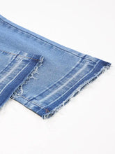 Blue denim whiskered wash cropped jeans with raw hem and visible stitching in a casual style