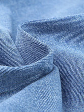Light blue denim raw hem cropped jeans with whiskered wash and classic twill weave texture